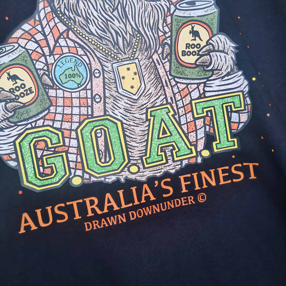 Black t-shirt with colorful graphic design featuring 'G.O.A.T. Australia's Finest' text and various elements.